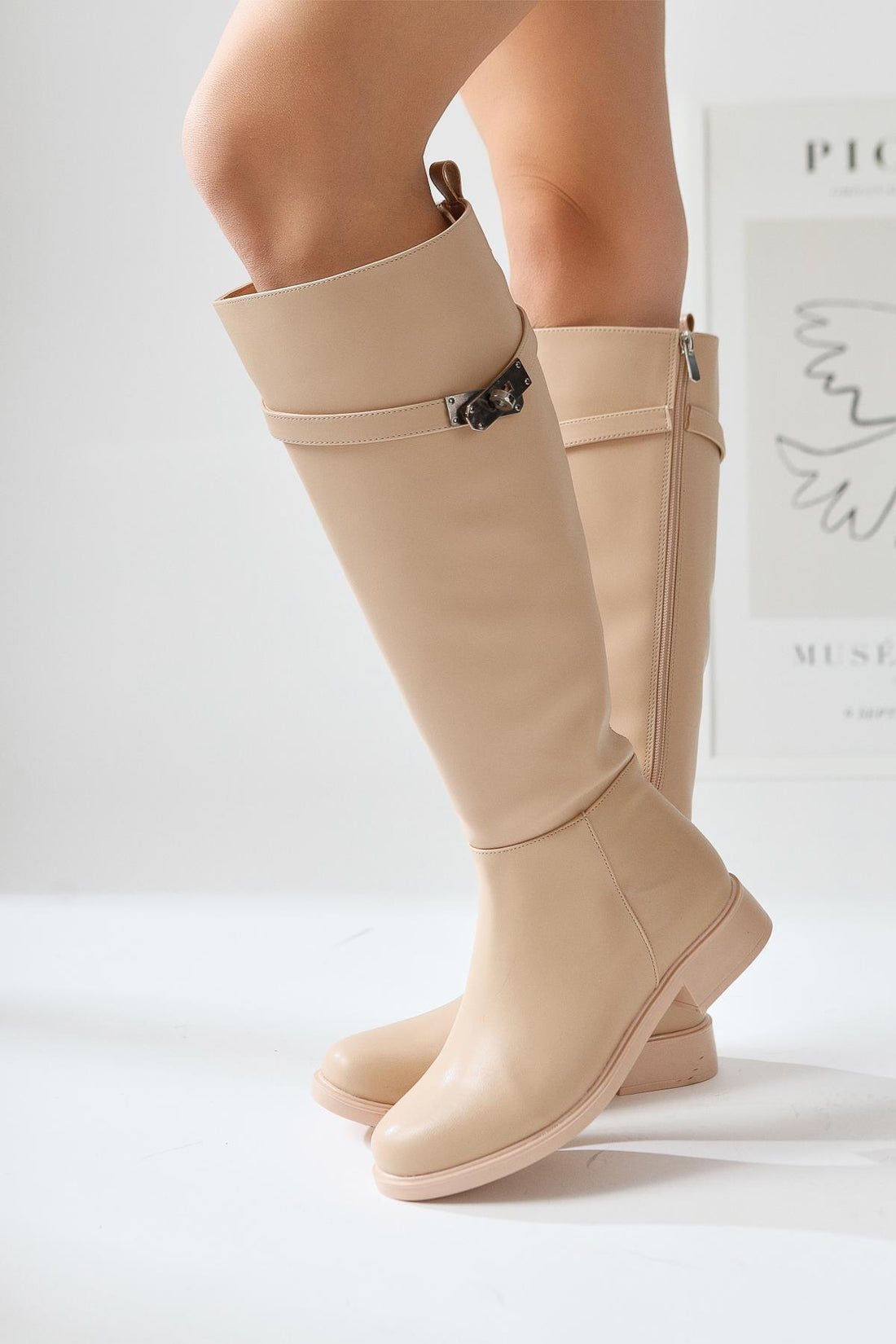 Kanako – Nude kniehoher Stiefel mit Reißverschluss, Accessoire-Detail und niedrigem Absatz
